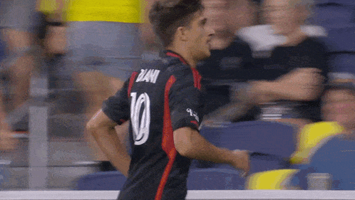 a soccer player wearing a black jersey with the number 10 on the back