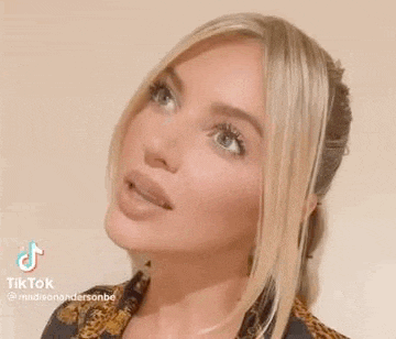 a close up of a woman 's face with long blonde hair .