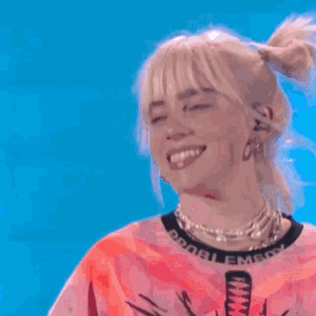 a woman in a white shirt is dancing on a stage in front of a crowd
