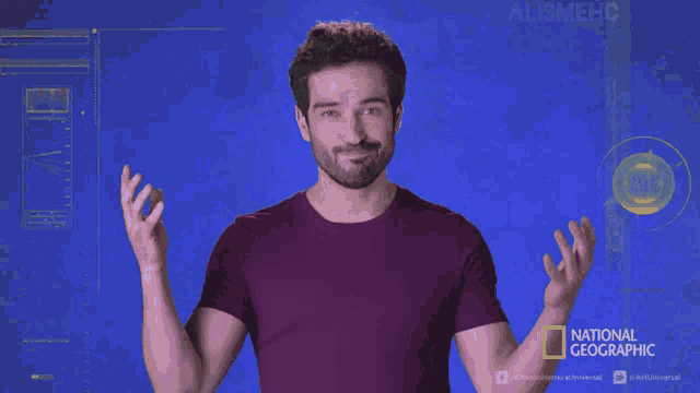 a man in a national geographic shirt holds something in his hands