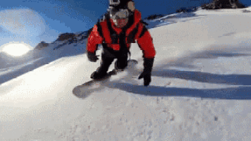 a snowboarder wearing a red jacket and goggles is riding down a snowy hill