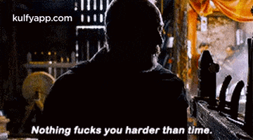 a man is standing in front of a window and says `` nothing fucks you harder than time . ''