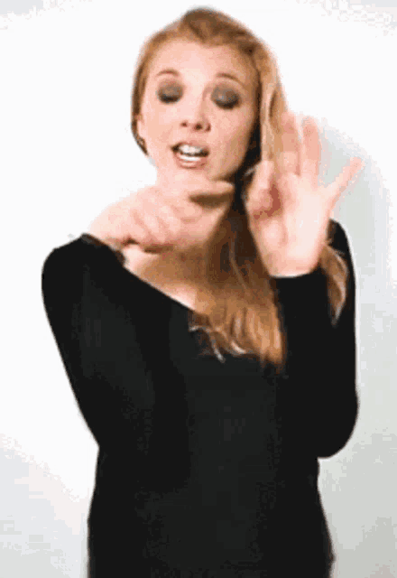 a woman in a black top is making a funny face