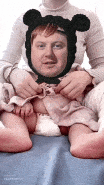a woman is holding a baby with a mickey mouse hat on her head