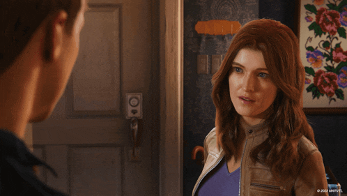 a woman in a brown leather jacket is standing next to a man in a room