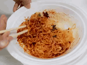 a bowl of noodles with chopsticks in it