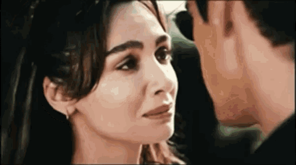 a man and a woman are kissing in a car and the woman is crying .