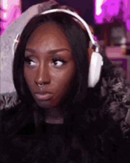 a woman wearing headphones and a nose ring is looking at the camera .