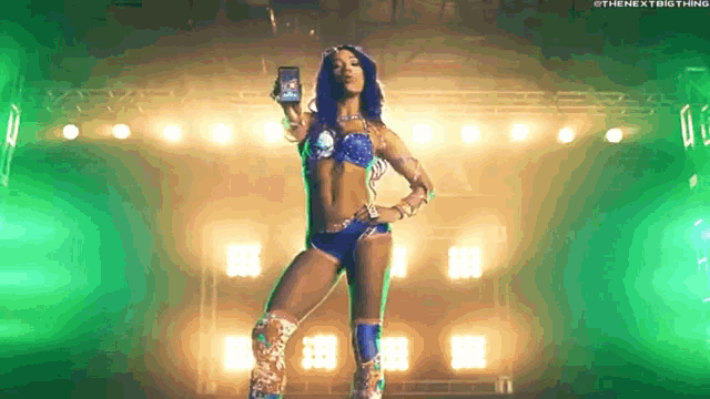 a woman in a bikini is standing on a stage holding a phone .