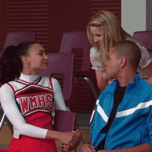 a cheerleader wearing a wmhs shirt shakes hands with a man