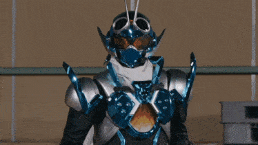 a man in a black and blue superhero costume is standing in a warehouse