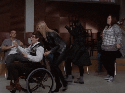 a woman in a leather jacket is dancing with a group of people