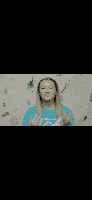 a woman wearing a blue shirt that says empower is making a gesture with her hands