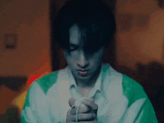 a young man in a green and white sweater is holding a rope in his hands .