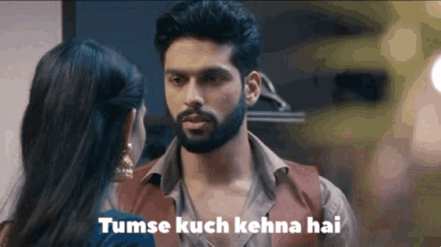 a man and woman are looking at each other with a caption that says tumse kuch kehna hai .
