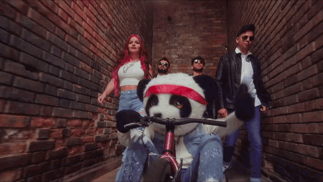 a group of people standing next to a stuffed panda wearing sunglasses