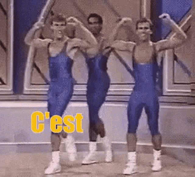 three men in blue leotards are flexing their muscles with the word c'est in yellow