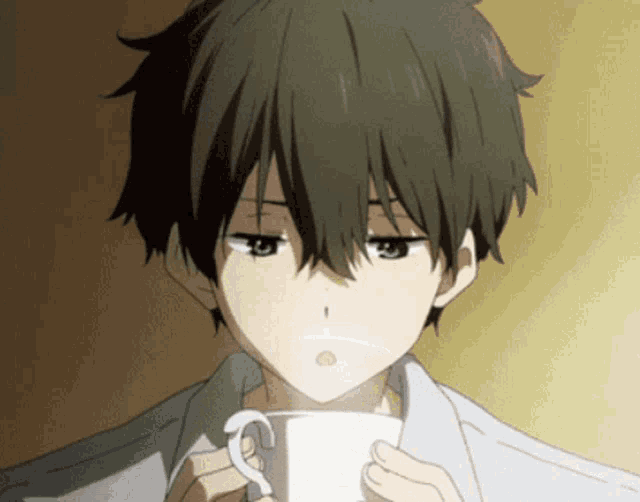 a boy with dark hair is holding a white cup