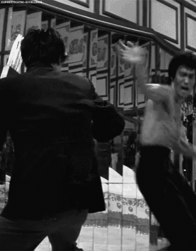 a man without a shirt is fighting another man in a black and white photo