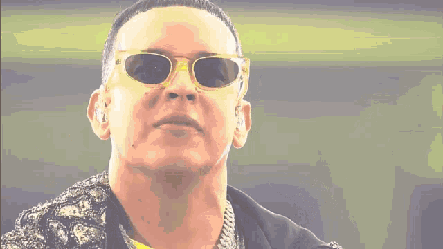 a close up of a man wearing sunglasses and a chain