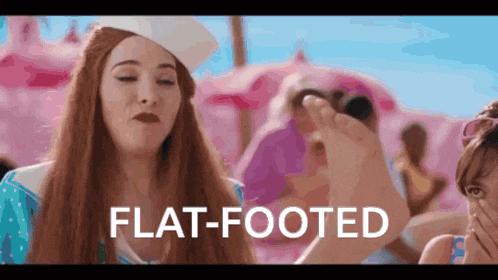a woman in a sailor hat is holding another woman 's foot with the words flat-footed written below her