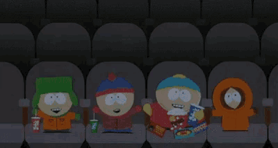 four south park characters are sitting in a dark auditorium