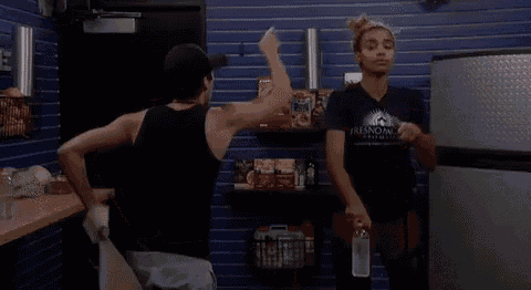 two women are standing next to each other in a store . one of the women is holding a bottle of water .