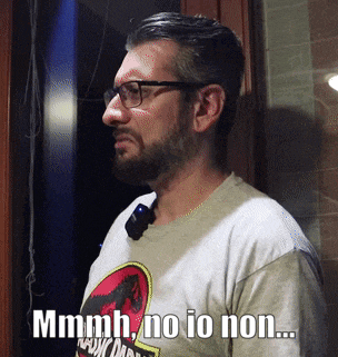 a man wearing glasses and a shirt that says ' mmmmh no io non ... '