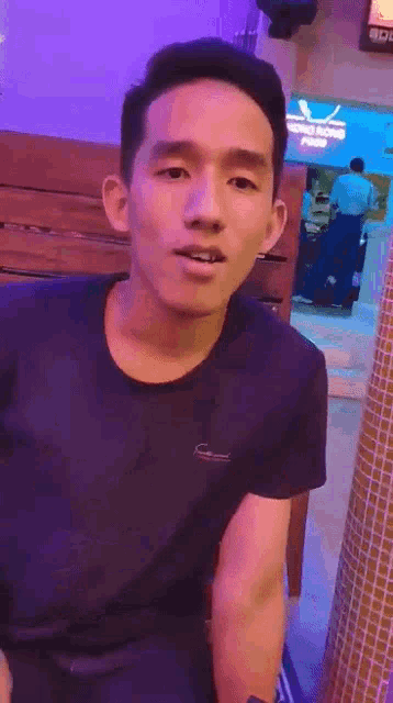 a man in a black shirt is standing in front of a sign that says hong kong food