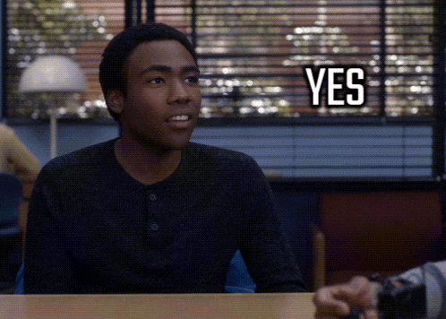 a man sitting at a desk with a yes sign above his head