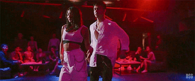 a man and a woman are dancing together in a nightclub .