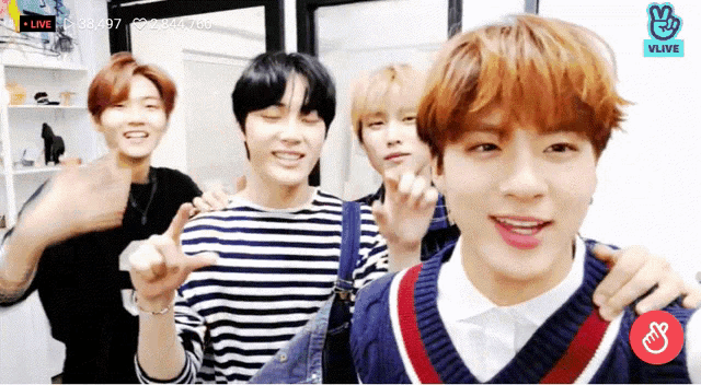a group of young men are standing next to each other with a vlive icon on the bottom left