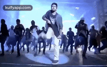 a man is dancing in front of a group of people .