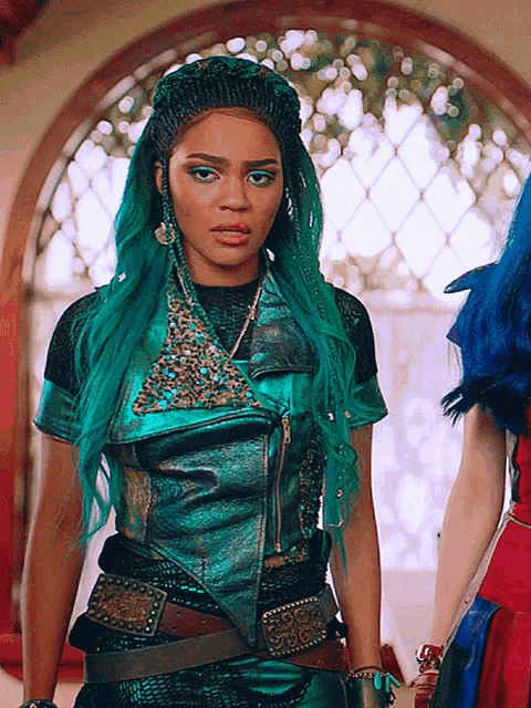 a woman with blue hair is wearing a green leather jacket