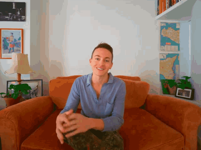 a man sitting on a couch with a map on the wall that says italy