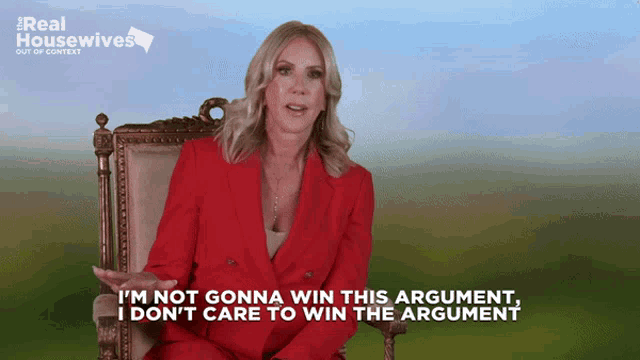 a woman in a red suit is sitting in a chair with the words i 'm not gonna win this argument