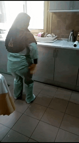 a woman standing in a kitchen wearing a shirt that says ' ec ' on it