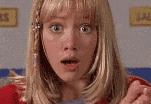 a close up of a woman 's face with her mouth open and a surprised look on her face .