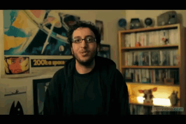 a man stands in front of a wall with a poster that says 2001 on it
