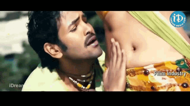 a man is touching a woman 's stomach in a video that is sponsored by film industry