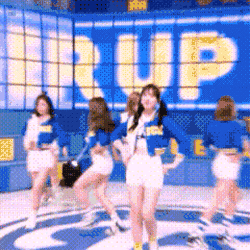 a group of cheerleaders are dancing in front of a sign that says ' up '