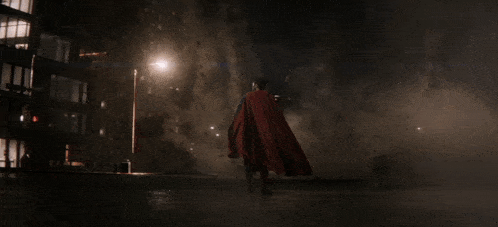 a man in a red cape is standing in front of a building that says new york city police