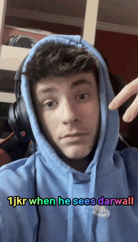 a man wearing headphones and a blue hoodie with the words 1jkr when he sees darwall