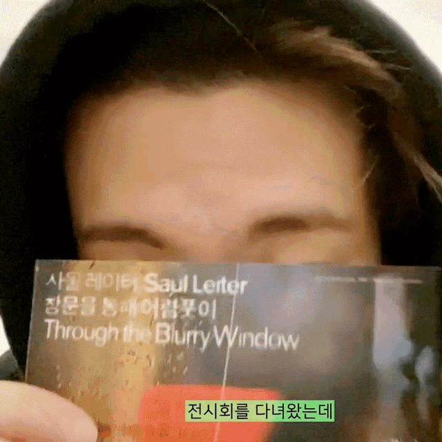 a man is holding a card that says through the blurry window