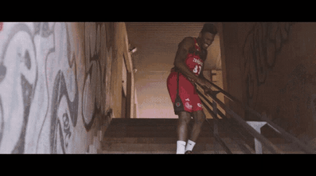 a basketball player wearing a number 87 jersey climbs stairs