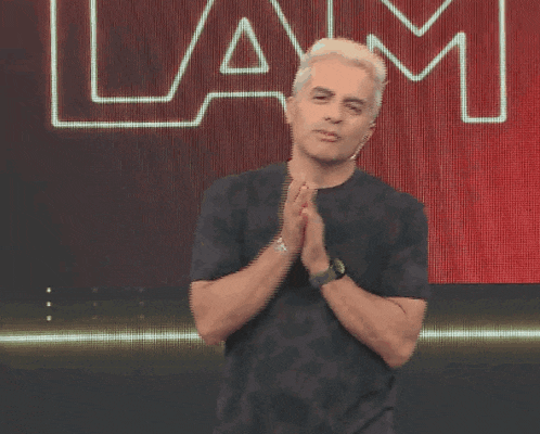 a man in a black shirt is standing in front of a lam sign