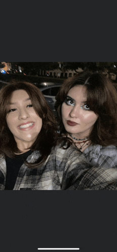 two girls are posing for a picture and one of them is wearing a choker