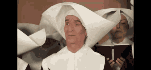 a man in a nun 's outfit is looking up at something