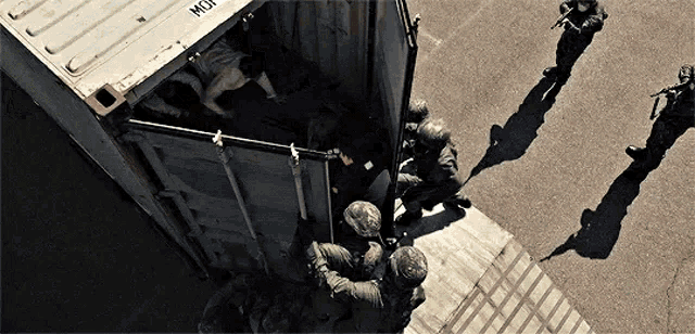 a group of soldiers are getting out of a container that says mgi on it
