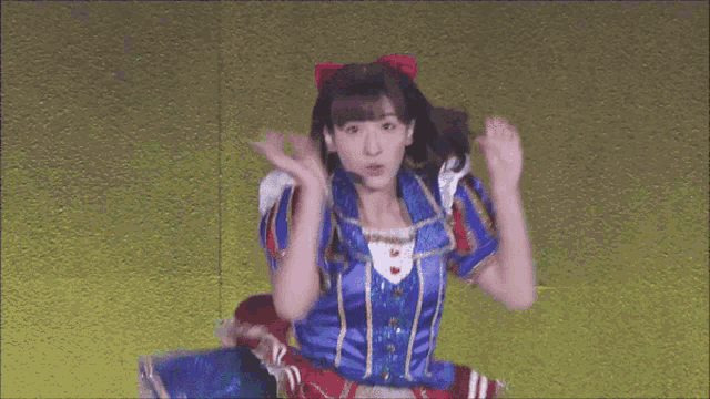 a girl in a blue and white costume with a red bow in her hair